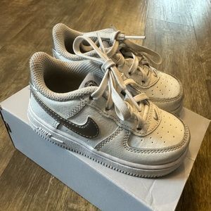 Air Force 1 Toddler sneaker in color white and metallic silver size 7C.